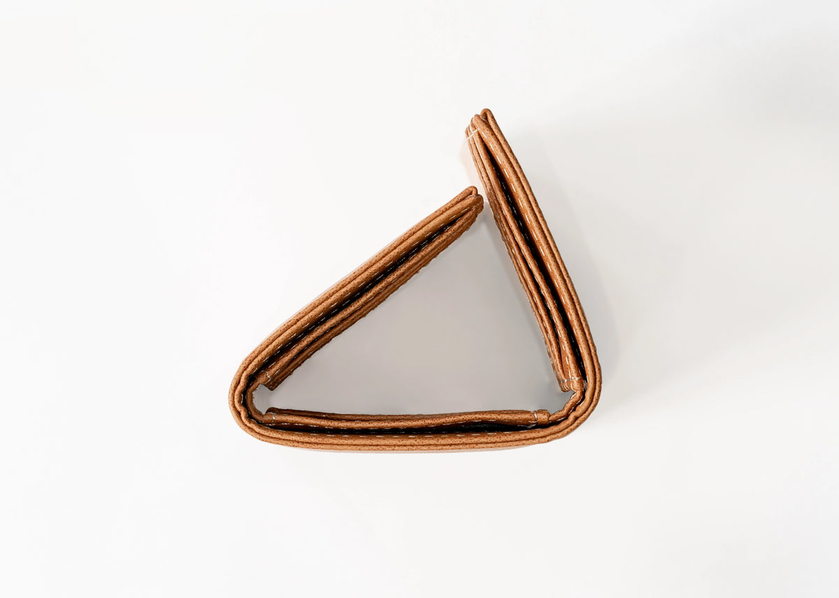 A triangular brown leather North Carolina Tar Heels wallet with stitched edges, photographed on a clean white background.